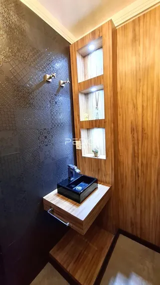Parede com revestimento escuro e painel de madeira em um ambiente interno.