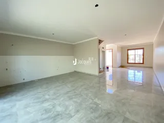 Ambiente interno de uma sala grande com piso de cerâmica.