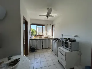 Cozinha com piso de cerâmica e armários brancos.