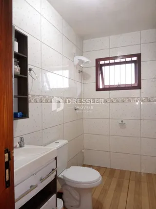 Foto de um banheiro com revestimento de cerâmica branca.