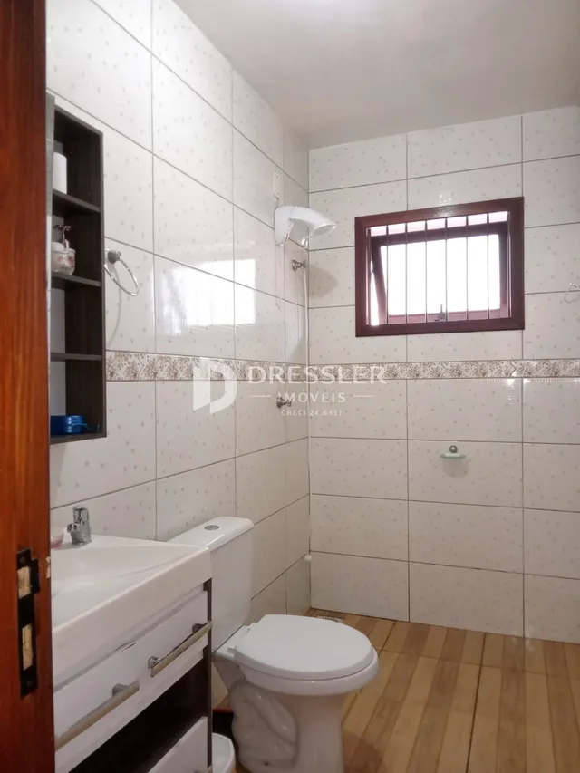 Foto de um banheiro com revestimento de cerâmica branca.