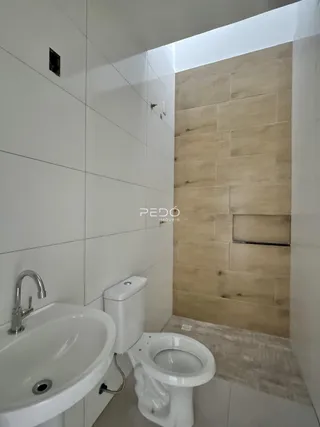 Interior de um banheiro com pia e vaso sanitário.