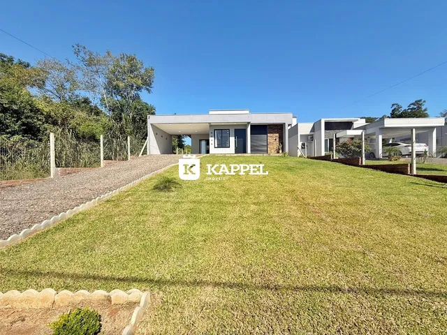 Fachada de uma casa moderna com gramado em primeiro plano em Lajeado, Brasil.