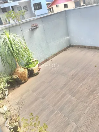 Vista externa de um pátio pavimentado ao lado de uma parede.