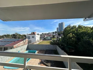 Vista de um imóvel com piscina e paisagem urbana ao fundo.