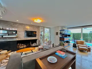 Sala de estar moderna com lareira e vista para o exterior.
