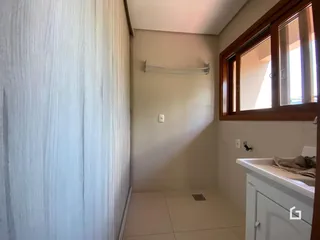 Foto de um ambiente interno com piso de cerâmica e janela de madeira.