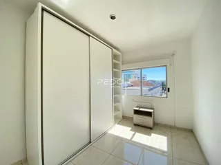 Vista interna de um corredor com armários embutidos e janela em um imóvel no Brasil.