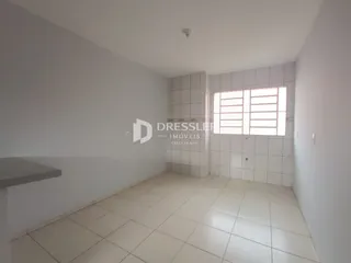 Ambiente interno de uma sala com piso de cerâmica clara e paredes brancas.