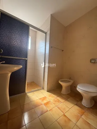 Interior de um banheiro com piso de cerâmica e azulejos nas paredes.