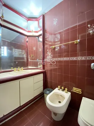 Banheiro com revestimento de cerâmica e bancada branca.