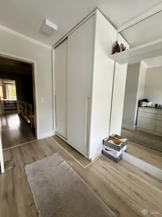 Quarto com armário embutido e piso de madeira clara.