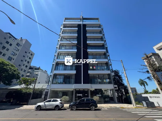 Foto da fachada de um prédio residencial moderno em Lajeado, Brasil, sob um céu azul claro.