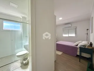Quarto com cama e piso de madeira em um imóvel no Brasil.
