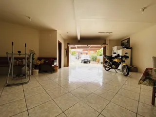 Interior de uma sala de estar com piso de cerâmica e área de passagem.