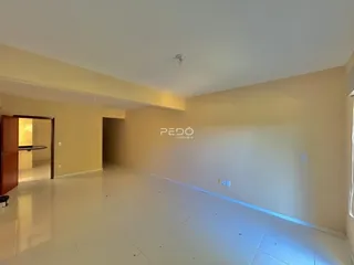 Ambiente interno de uma sala ampla com piso de cerâmica clara.