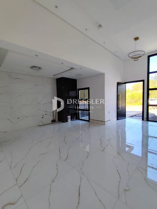 Sala ampla com piso de mármore branco polido.