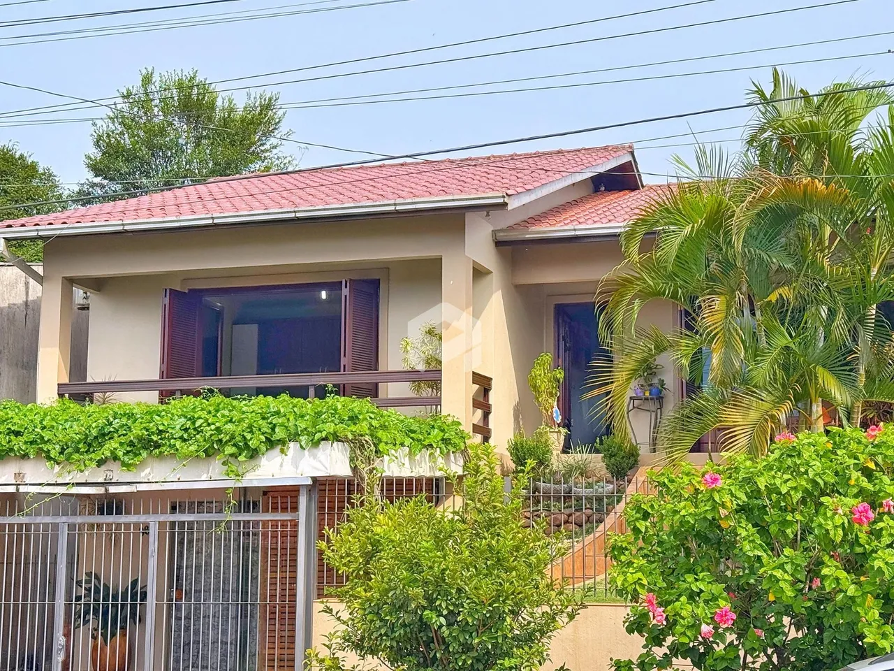 Fachada de uma casa em Lajeado, Brasil, com vegetação exuberante na frente.