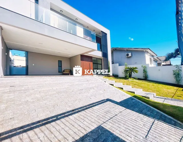 Fachada moderna de um prédio residencial com área de estacionamento pavimentada.