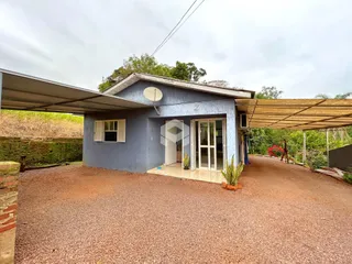 Fachada de uma casa em Lajeado, Brasil, com garagem e área externa de cascalho.