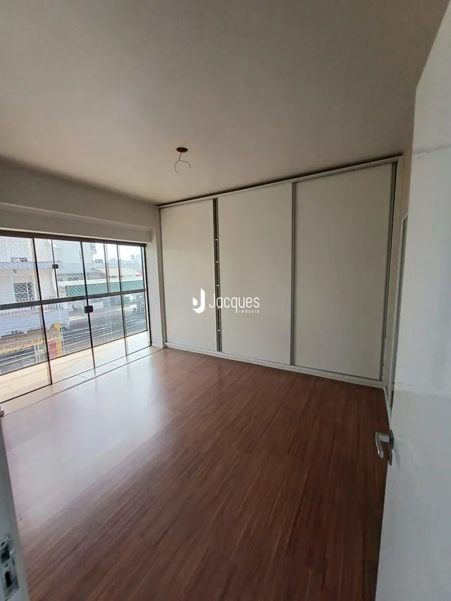 Quarto com piso de madeira e armários embutidos.