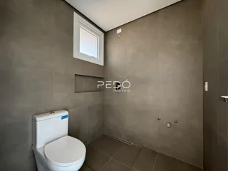 Foto de um banheiro com revestimento de cerâmica e janela.