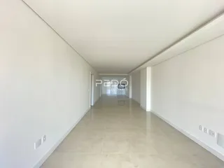 Corredor interno de uma residência com paredes brancas e piso claro.