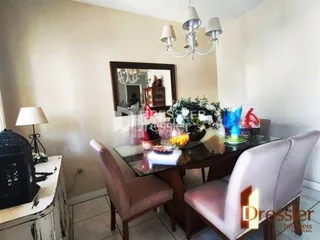 Uma mesa de jantar com cadeiras e um espelho decoram o ambiente interno.