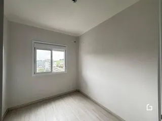 Ambiente interno com piso de madeira clara e janela.