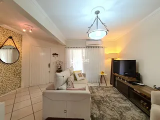 Sala de estar com sofá branco e piso de cerâmica.