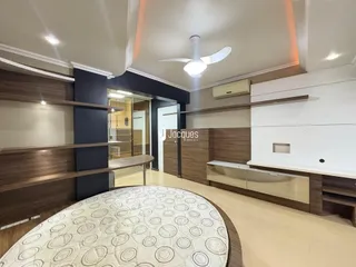 Ambiente interno de uma sala com revestimento de madeira e piso claro.