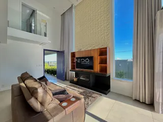 Sala de estar com sofá e janela grande em um imóvel no Brasil.