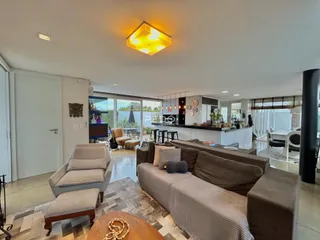 Sala de estar com sofá e piso de cerâmica em um imóvel no Brasil.