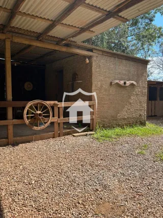 Fachada de uma residência com estrutura de tijolos e área externa de cascalho.