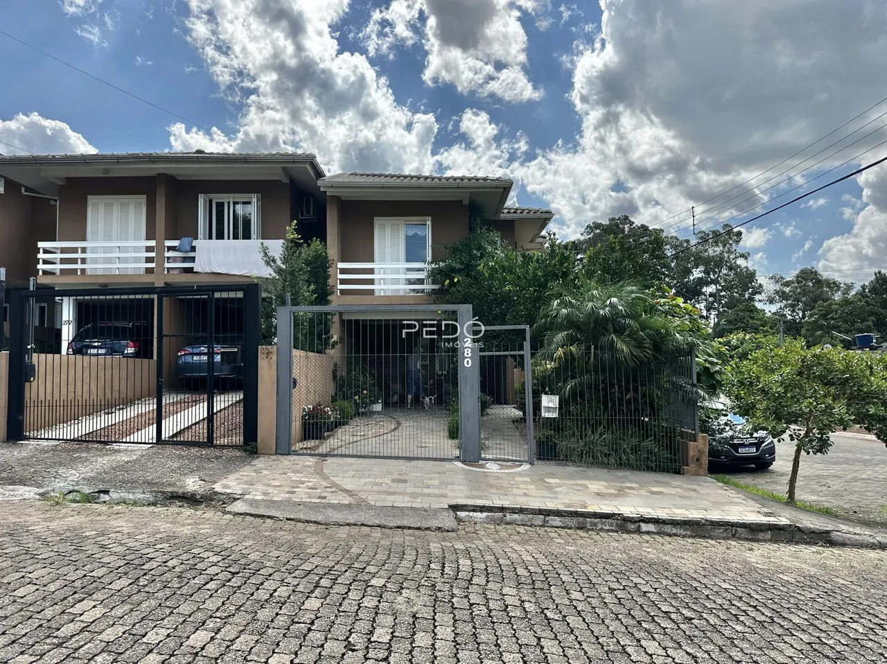 Fachada de uma residência em Lajeado, Brasil, com portão de ferro.