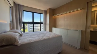 Quarto com cama grande e janela ampla.