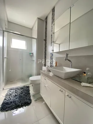 Foto de um banheiro moderno com piso de cerâmica e bancada branca.