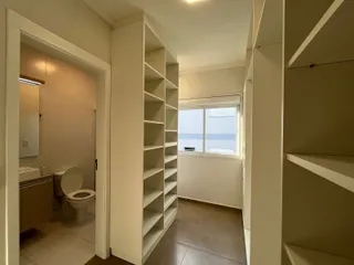 Foto de um corredor interno com acesso a um banheiro e estantes.