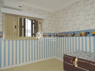 Quarto interno com parede decorada e janela.