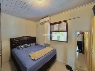 Quarto com cama e janela em imóvel no Brasil.