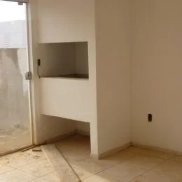 Vista parcial de um cômodo interno com paredes brancas e piso de cerâmica.