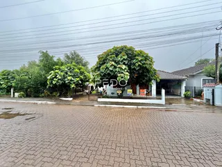 Vista da fachada de uma propriedade em Lajeado, Brasil, com vegetação densa e cerca.