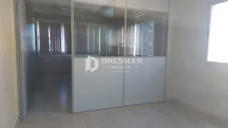 Hall de entrada com divisória de vidro entre os cômodos.