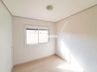 Foto de um cômodo interno com paredes brancas e piso de madeira.