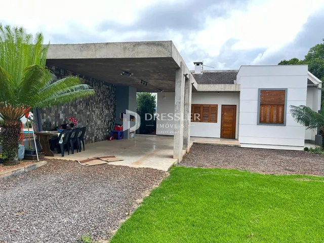 Vista externa de uma residência moderna com área de concreto e jardim.