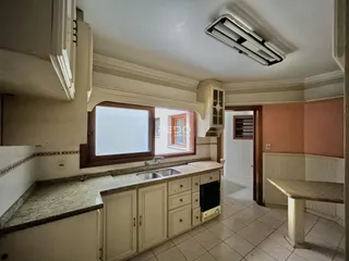 Vista interna de uma cozinha com armários e bancadas em um imóvel no Brasil.