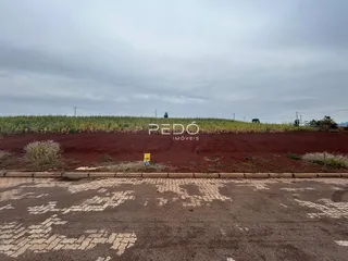 Vista da propriedade com campo de cultivo ao fundo.