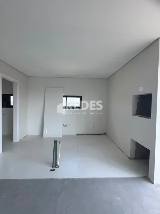 Interior de uma sala vazia com paredes brancas.