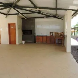 Ambiente interno com piso claro e estrutura de teto exposta.