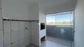 Vista de um corredor interno com paredes brancas e piso de cerâmica.
